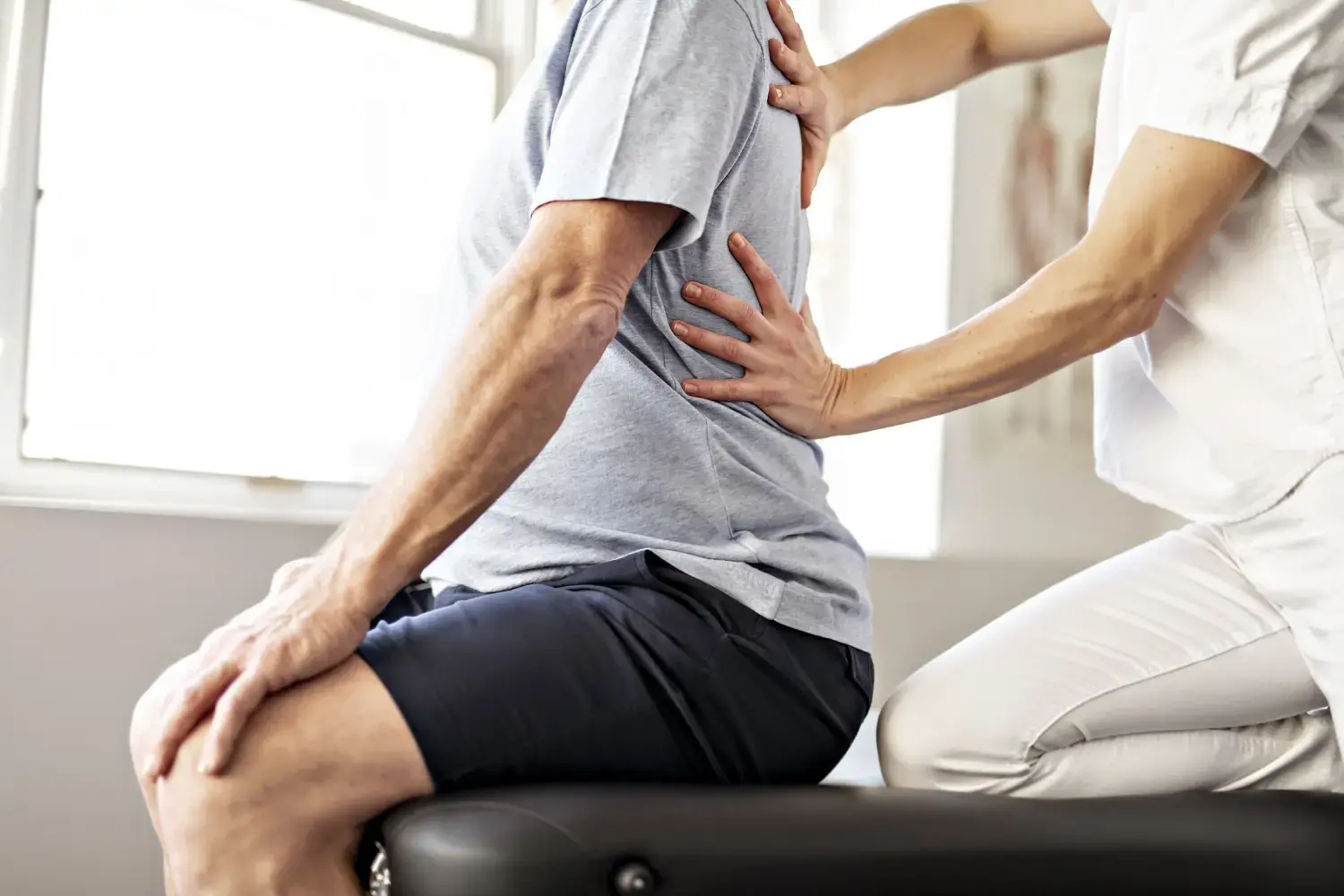 Eine moderne Rehabilitations-Physiotherapeutin mit einem älteren Kunden